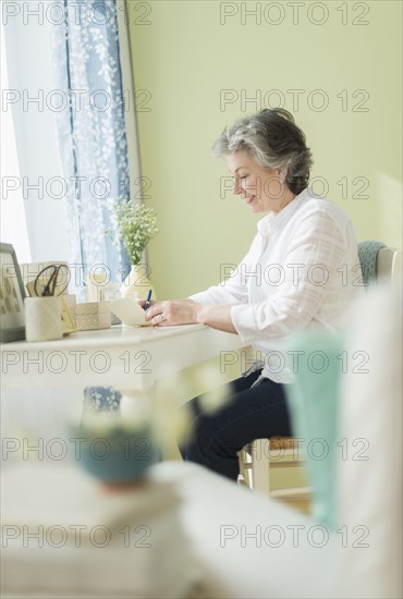 Mature woman writing letter.