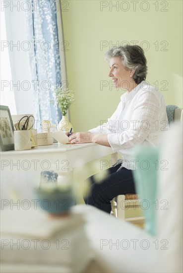 Mature woman writing letter.