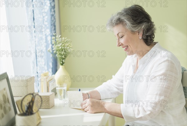 Mature woman writing letter.