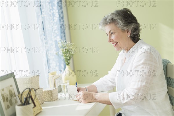 Mature woman writing letter.