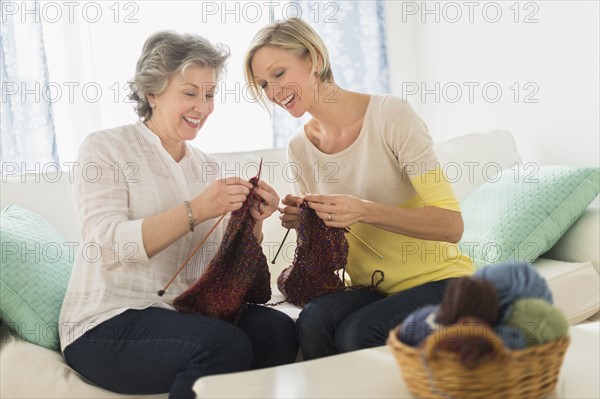 Two mature women knitting.