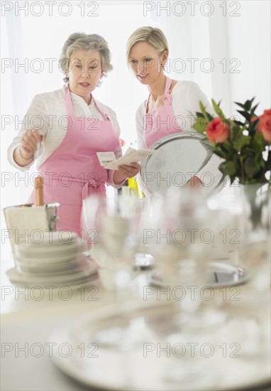 Two mature women preparing catering.