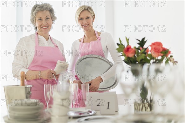 Two mature women preparing catering.