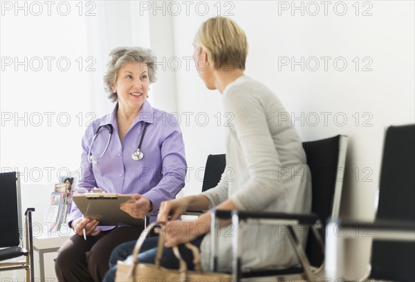 Doctor talking to patient in waiting room.