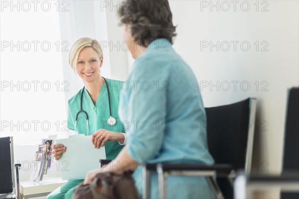 Doctor talking to patient in waiting room.