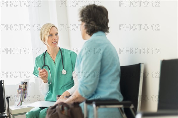 Doctor talking to patient in waiting room.