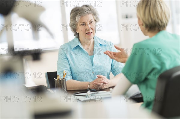 Doctor talking to patient in doctor's office.