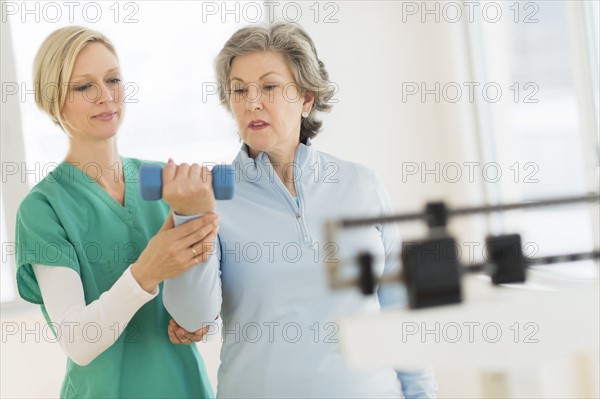 Mature woman exercising with personal trainer.