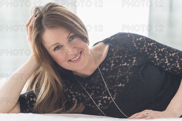 Portrait of attractive woman relaxing on bed.