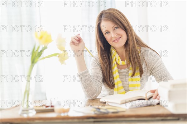 Portrait of smiling woman sitting at desk.
