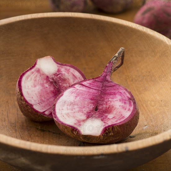 Studio shot cut Japanese red turnip in wooden bowl.