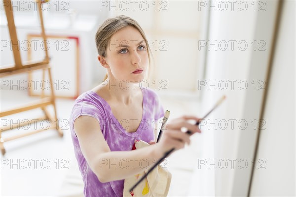 Female artist painting in studio.