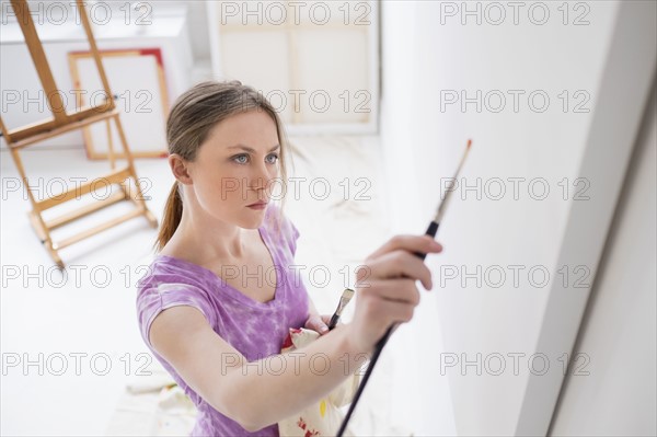 Female artist painting in studio.