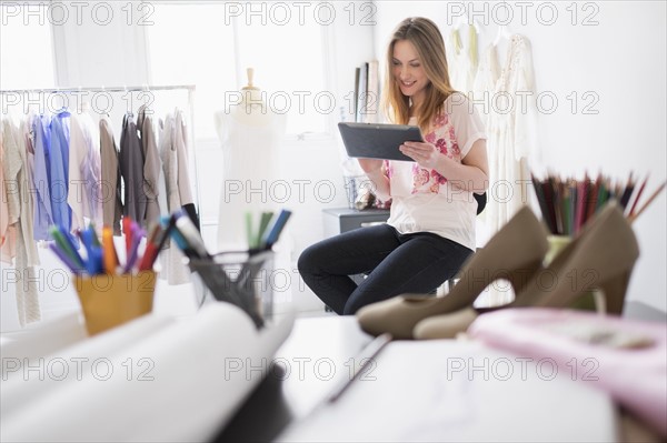 Portrait of female costume designer using digital tablet in studio.