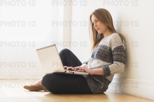 Portrait of young woman using laptop.