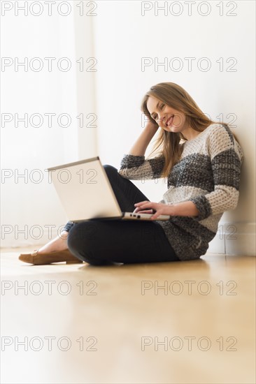 Portrait of young woman using laptop.