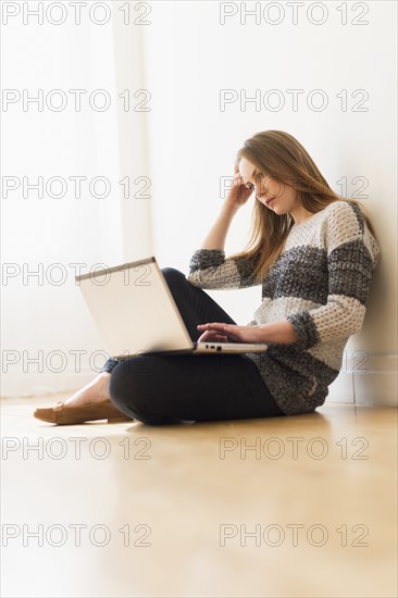 Portrait of young woman using laptop.