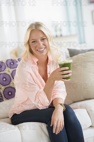 Portrait of young woman holding smoothie.
Photo : Jamie Grill