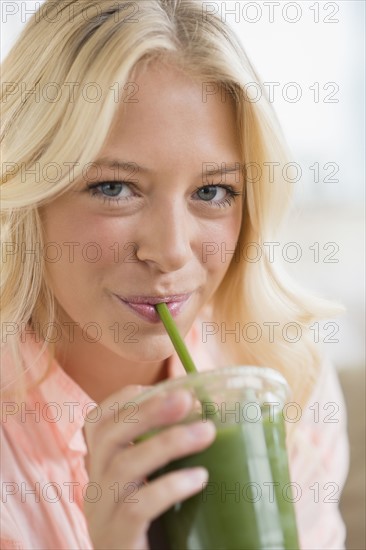 Portrait of young woman drinking smoothie.
Photo : Jamie Grill