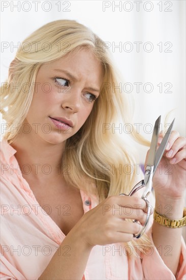 Portrait of young woman cutting hair.
Photo : Jamie Grill