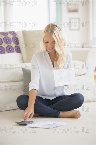 Portrait of young woman calculating bills.
Photo : Jamie Grill