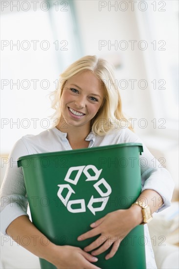 Portrait of young woman holding recycling bin.
Photo : Jamie Grill
