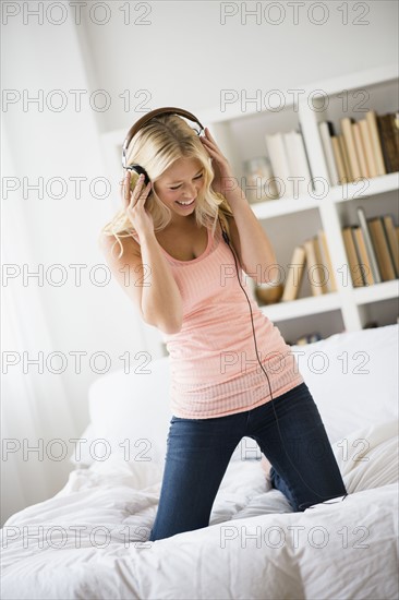 Young woman listening to music in bedroom.
Photo : Jamie Grill