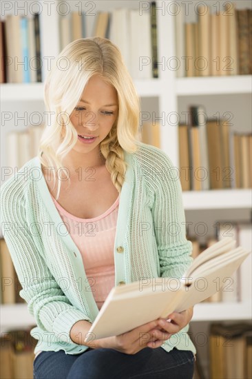 Portrait of young woman reading in library.
Photo : Jamie Grill
