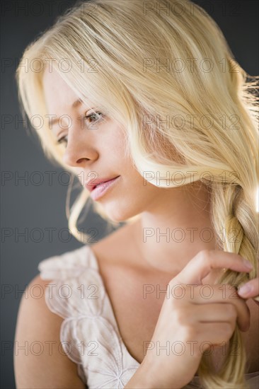 Portrait of young woman braiding hair.
Photo : Jamie Grill