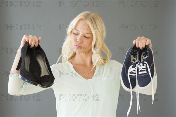 Portrait of young woman holding shoes.
Photo : Jamie Grill