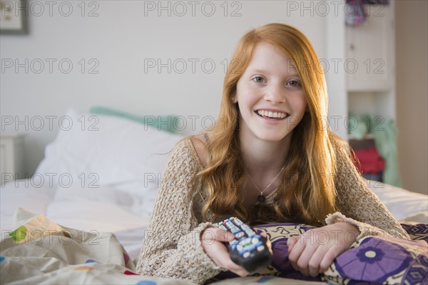 Portrait of girl (12-13) lying on bed.
Photo : Jamie Grill