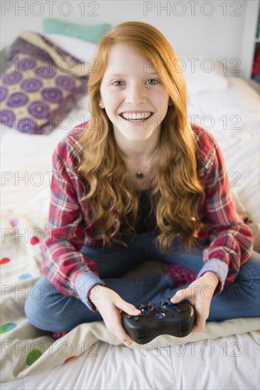 Portrait of girl (12-13) playing video games.
Photo : Jamie Grill