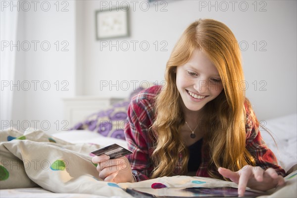 Portrait of girl (12-13) doing on-line shopping.
Photo : Jamie Grill