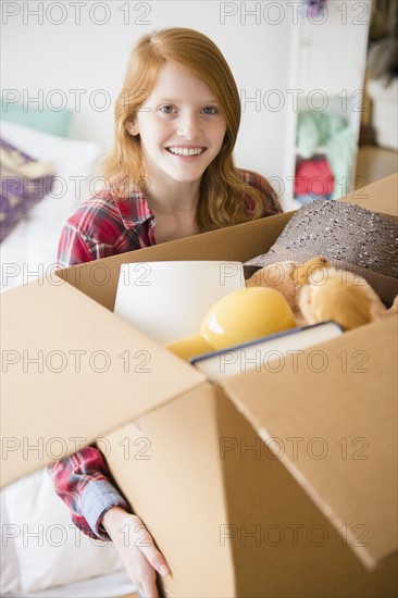 Portrait of girl (12-13) holding box.
Photo : Jamie Grill