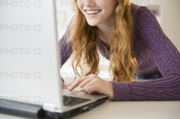 Girl (12-13) using laptop, mid section.
Photo : Jamie Grill