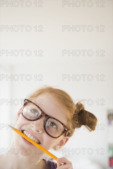 Girl (12-13) holding pencil in mouth.
Photo : Jamie Grill