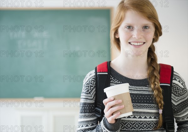 Portrait of girl (12-13) holding disposable cup.
Photo : Jamie Grill