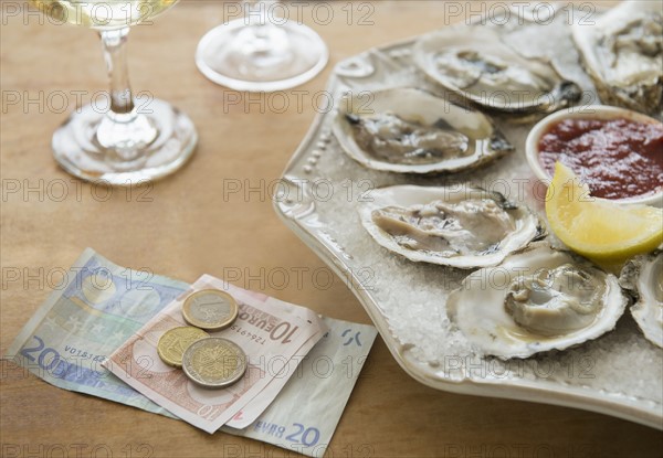 Studio shot of oysters and money.
Photo : Jamie Grill