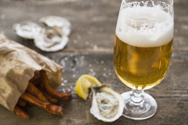 Studio shot of glass of beer, oysters and french fries.
Photo : Jamie Grill