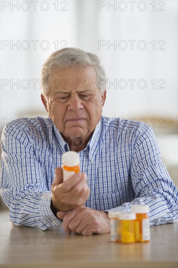 Senior man holding pill bottle.
Photo : Jamie Grill