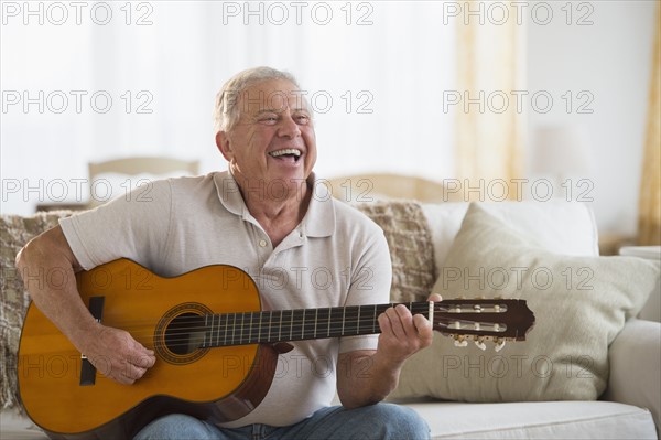 Senior man playing guitar.
Photo : Jamie Grill