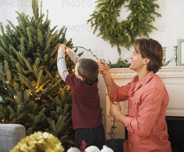 Man with kid (6-7) decorating Christmas tree.
Photo : Daniel Grill