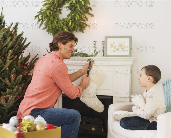 Man with kid (6-7) decorating fireplace.
Photo : Daniel Grill