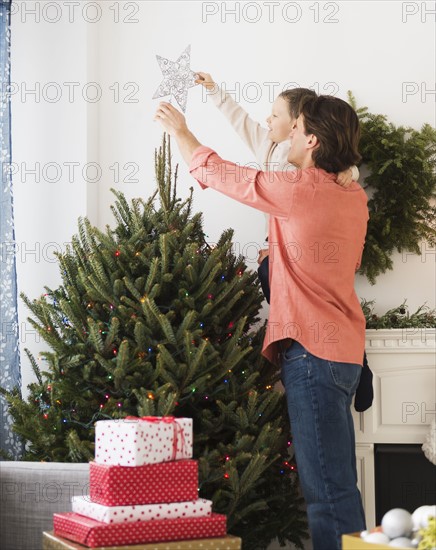 Man with kid (6-7) decorating Christmas tree.
Photo : Daniel Grill