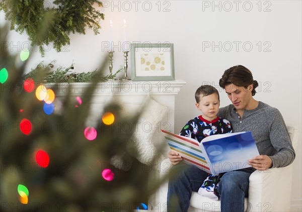Man reading book with boy (6-7).
Photo : Daniel Grill