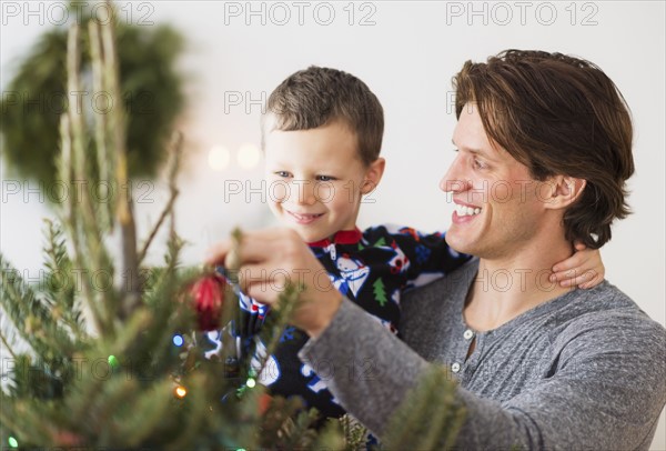 Man with kid (6-7) decorating Christmas tree.
Photo : Daniel Grill