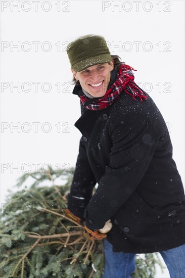 Man carrying Christmas tree.
Photo : Daniel Grill