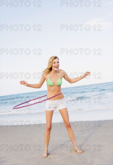 Young woman on beach twirling Hula hoop. Jupiter, Florida, USA.
Photo : Daniel Grill