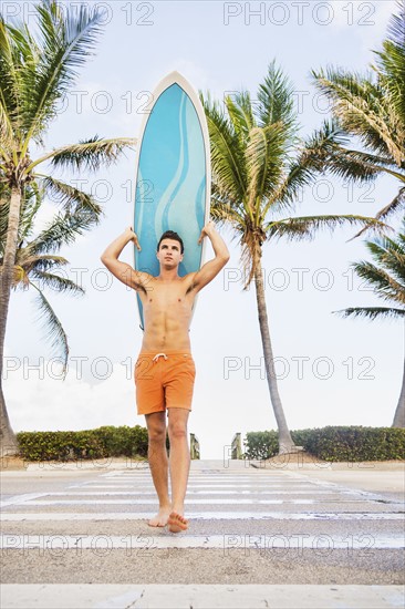 Young man carrying surfboard. Jupiter, Florida, USA.
Photo : Daniel Grill