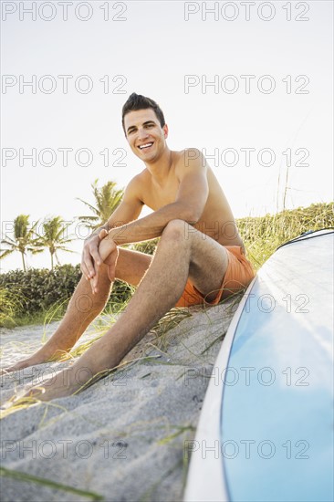 Young man sitting on beach with surfboard. Jupiter, Florida, USA.
Photo : Daniel Grill